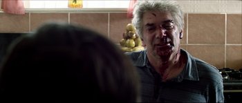 Movie still from “Kill List” (2011), directed by Ben Wheatley – A man with blood all over his face; Close Up shot, Over the shoulder angle