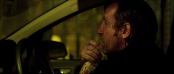 Movie still from “Kill List” (2011), directed by Ben Wheatley – A man sitting in the driver's seat of a car; Close Up shot, Over the shoulder angle