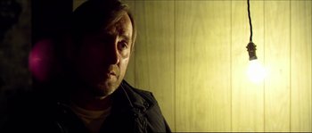 Movie still from “Kill List” (2011), directed by Ben Wheatley – A person wearing a black jacket; Close Up shot, Over the shoulder angle