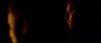 Movie still from “Kill List” (2011), directed by Ben Wheatley – A man is looking into the distance in the dark; Close Up shot, Low angle