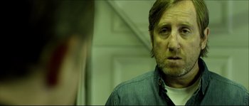 Movie still from “Kill List” (2011), directed by Ben Wheatley – A person wearing a blue shirt; Close Up shot, Over the shoulder angle