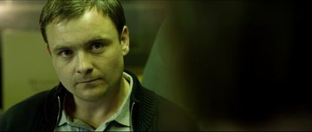 Movie still from “Kill List” (2011), directed by Ben Wheatley – A person wearing a jacket; Close Up shot, Over the shoulder angle