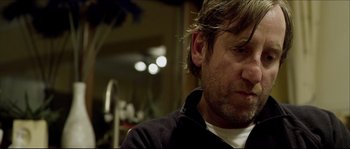 Movie still from “Kill List” (2011), directed by Ben Wheatley – A person wearing a black jacket; Close Up shot, Over the shoulder angle