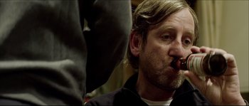 Movie still from “Kill List” (2011), directed by Ben Wheatley – A person with a beard and mustache; Close Up shot, Over the shoulder angle