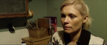 Movie still from “Kill List” (2011), directed by Ben Wheatley – A person sitting in a room; Close Up shot, High angle