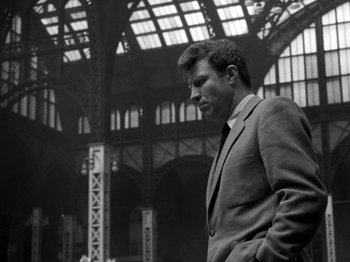 Movie still from “Killer's Kiss” (1955), directed by Stanley Kubrick – A black and white photo of a man in a suit; Medium shot, Low angle