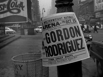 Movie still from “Killer's Kiss” (1955), directed by Stanley Kubrick – An old photo of a newspaper on a pole; Wide shot, High angle
