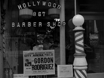 Movie still from “Killer's Kiss” (1955), directed by Stanley Kubrick – A black and white photo of a barber shop; Wide shot, Low angle