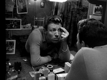 Movie still from “Killer's Kiss” (1955), directed by Stanley Kubrick – A black and white photo of a man looking at himself in the mirror; Close Up shot, High angle
