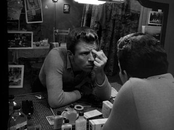 Movie still from “Killer's Kiss” (1955), directed by Stanley Kubrick – A black - and - white photo of a man looking at himself in the mirror; Medium shot, High angle