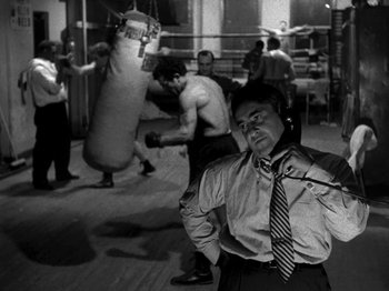 Movie still from “Killer's Kiss” (1955), directed by Stanley Kubrick – A black and white photo of a man in a boxing ring; Medium shot, Low angle