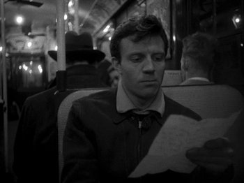 Movie still from “Killer's Kiss” (1955), directed by Stanley Kubrick – A man sitting on a bus looking at a paper; Close Up shot, High angle
