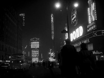 Movie still from “Killer's Kiss” (1955), directed by Stanley Kubrick – A black - and - white photo of a city street at night; Extreme Wide shot, Low angle