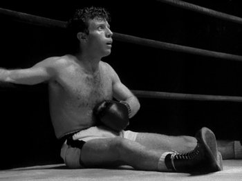 Movie still from “Killer's Kiss” (1955), directed by Stanley Kubrick – Black and white photograph of a man sitting in a boxing ring; Medium shot, Low angle