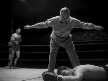 Movie still from “Killer's Kiss” (1955), directed by Stanley Kubrick – An old man standing over a man on the ground; Medium shot, Low angle
