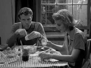 Movie still from “Killer's Kiss” (1955), directed by Stanley Kubrick – A man and a woman sitting at a table; Medium shot, High angle
