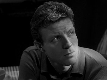Movie still from “Killer's Kiss” (1955), directed by Stanley Kubrick – Black and white photograph of a young man looking to his left; Close Up shot, Low angle