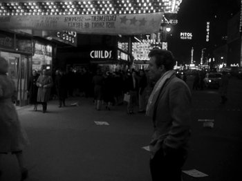 Movie still from “Killer's Kiss” (1955), directed by Stanley Kubrick – A black and white photo of a man walking on the street; Wide shot, High angle