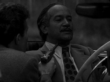 Movie still from “Killer's Kiss” (1955), directed by Stanley Kubrick – A black and white photo of a man in a suit and tie; Close Up shot, Over the shoulder angle