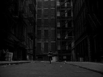 Movie still from “Killer's Kiss” (1955), directed by Stanley Kubrick – A person walking down a street in a dark city; Extreme Wide shot, High angle