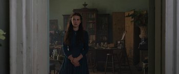 Movie still from “Enola Holmes” (2020), directed by Harry Bradbeer – A woman standing in front of a room with a lot of furniture; Medium shot, Low angle