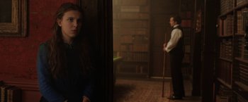 Movie still from “Enola Holmes” (2020), directed by Harry Bradbeer – A man and a woman standing in a room; Medium shot, Over the shoulder angle