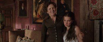 Movie still from “Enola Holmes” (2020), directed by Harry Bradbeer – A woman standing next to a young girl in front of a painting; Medium shot, Over the shoulder angle