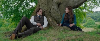 Movie still from “Enola Holmes” (2020), directed by Harry Bradbeer – A man and a woman sitting next to a tree; Medium shot, High angle