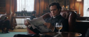 Movie still from “Enola Holmes” (2020), directed by Harry Bradbeer – A man sitting at a table with a glass of wine; Medium shot, Over the shoulder angle