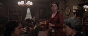 Movie still from “Enola Holmes” (2020), directed by Harry Bradbeer – A woman in a red dress standing in a room; Medium shot, Over the shoulder angle