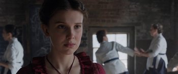 Movie still from “Enola Holmes” (2020), directed by Harry Bradbeer – A woman in a red dress standing in front of a window; Close Up shot, Over the shoulder angle