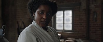 Movie still from “Enola Holmes” (2020), directed by Harry Bradbeer – A woman in a white robe stands in front of a window; Close Up shot, Over the shoulder angle