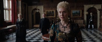 Movie still from “Enola Holmes” (2020), directed by Harry Bradbeer – An older woman and a man standing in a room; Medium shot, Over the shoulder angle