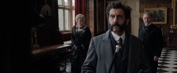 Movie still from “Enola Holmes” (2020), directed by Harry Bradbeer – A man and a woman standing in front of a window; Medium shot, Low angle