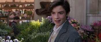 Movie still from “Enola Holmes” (2020), directed by Harry Bradbeer – A young man in a suit poses for a picture; Close Up shot, Over the shoulder angle