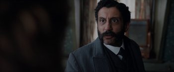 Movie still from “Enola Holmes” (2020), directed by Harry Bradbeer – A person wearing a suit and tie; Close Up shot, Over the shoulder angle