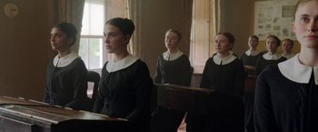 Movie still from “Enola Holmes” (2020), directed by Harry Bradbeer – A group of people in a room with a window; Medium shot, Low angle