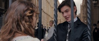 Movie still from “Enola Holmes” (2020), directed by Harry Bradbeer – A man in a suit and tie holding onto a rope; Close Up shot, Over the shoulder angle