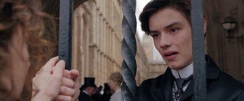 Movie still from “Enola Holmes” (2020), directed by Harry Bradbeer – A young man holding a sword in front of a building; Close Up shot, Low angle