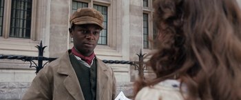 Movie still from “Enola Holmes” (2020), directed by Harry Bradbeer – A man wearing a hat standing next to a woman; Close Up shot, Over the shoulder angle