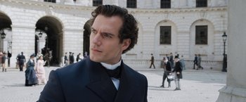 Movie still from “Enola Holmes” (2020), directed by Harry Bradbeer – A person wearing a suit and a bow tie; Close Up shot, Over the shoulder angle