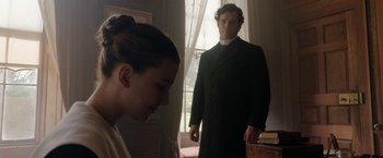Movie still from “Enola Holmes” (2020), directed by Harry Bradbeer – A man and a woman standing in front of a window; Medium shot, Over the shoulder angle