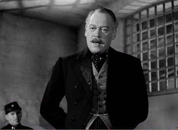 Movie still from “Kind Hearts and Coronets” (1949), directed by Robert Hamer – An older man wearing a suit and a tie; Close Up shot, Low angle