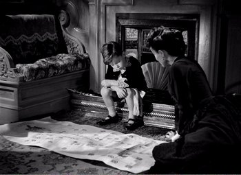 Movie still from “Kind Hearts and Coronets” (1949), directed by Robert Hamer – Two young boys sitting in front of an old piano; Medium shot, High angle