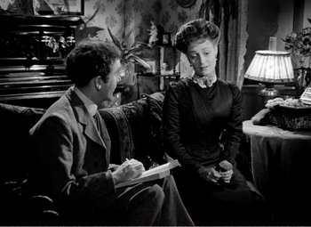 Movie still from “Kind Hearts and Coronets” (1949), directed by Robert Hamer – A man and a woman sitting on a couch; Medium shot, Over the shoulder angle