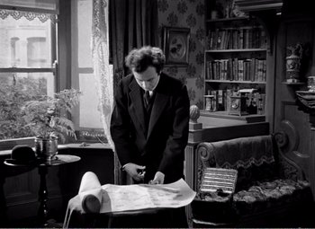 Movie still from “Kind Hearts and Coronets” (1949), directed by Robert Hamer – A black and white photo of a man in a suit and tie; Medium shot, High angle