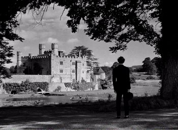 Movie still from “Kind Hearts and Coronets” (1949), directed by Robert Hamer – A man standing in front of an old castle; Extreme Wide shot, High angle