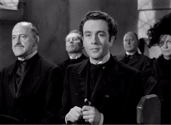 Movie still from “Kind Hearts and Coronets” (1949), directed by Robert Hamer – A group of men standing next to each other in a room; Medium shot, Low angle