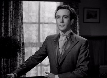 Movie still from “Kind Hearts and Coronets” (1949), directed by Robert Hamer – Black and white photograph of a man in a suit; Medium shot, Low angle