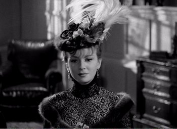 Movie still from “Kind Hearts and Coronets” (1949), directed by Robert Hamer – A black and white photo of a woman wearing a hat; Close Up shot, Over the shoulder angle